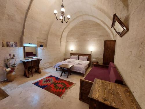 a bedroom with a bed and a table in a room at ARMEsos Cave Hotel in Urgup