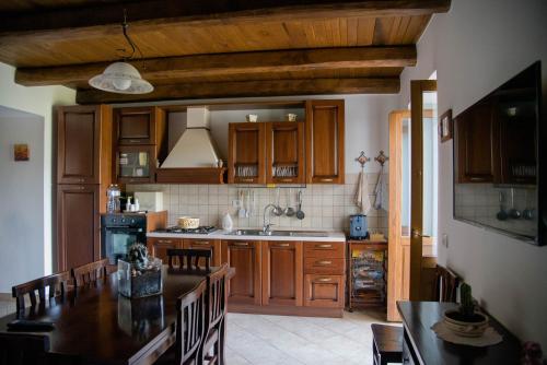 a kitchen with wooden cabinets and a table with chairs at Antico Sogno in Alfano