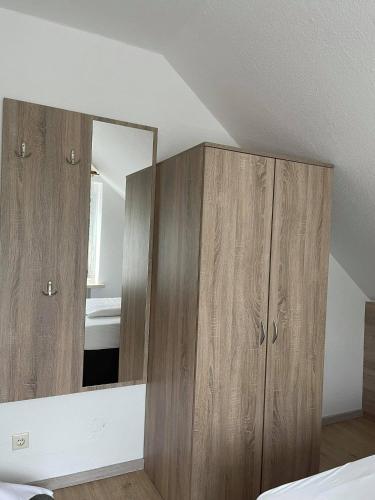 a bedroom with wooden cabinets and a mirror at Pension am Meer in Norddeich