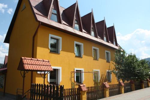 a yellow house with a brown roof at База відпочинку "Тростян" in Slavske