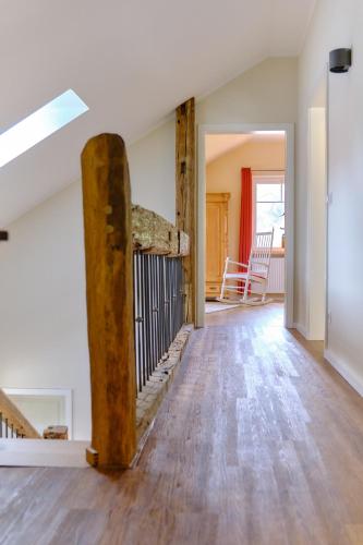 an open living room with a wooden floor and a staircase at Landhäuschen Anderswo in Bocholt