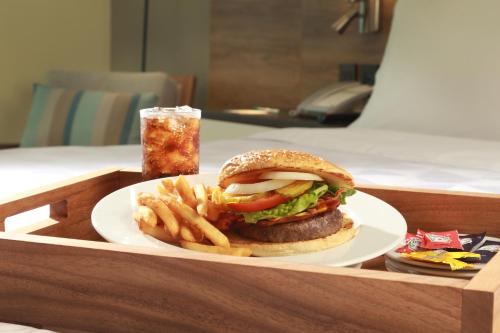 Un plato con una hamburguesa y papas fritas y una bebida. en Holiday Inn & Suites - Puerto Vallarta Marina & Golf by IHG, en Puerto Vallarta