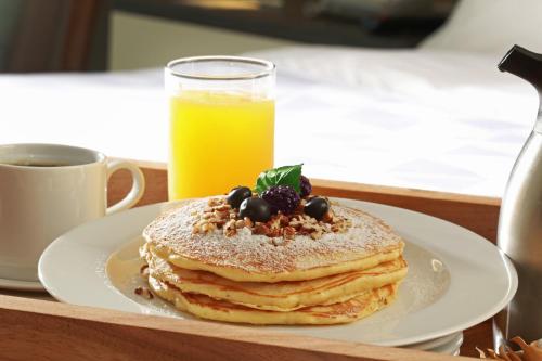 un plato con una pila de panqueques y un vaso de zumo de naranja en Holiday Inn & Suites - Puerto Vallarta Marina & Golf by IHG, en Puerto Vallarta