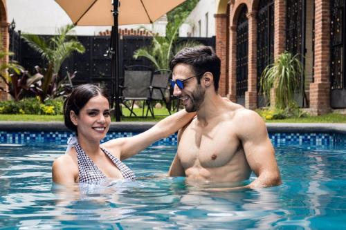 a man and a woman in a swimming pool at Hotel Boutique Sol y Luna SPA in Ajijic