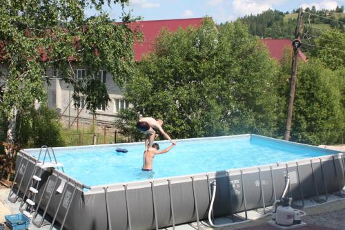 Dos personas están en una piscina en База відпочинку "Тростян" en Slavske