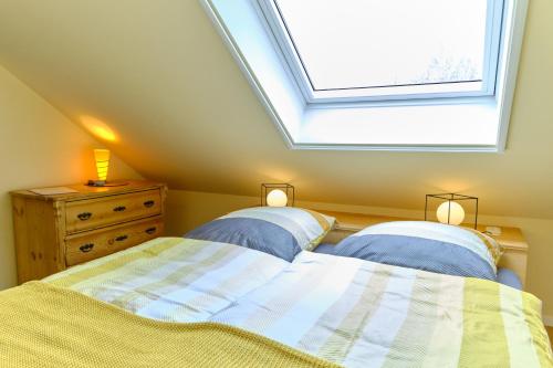 a attic bedroom with two beds and a skylight at Landhäuschen Anderswo in Bocholt