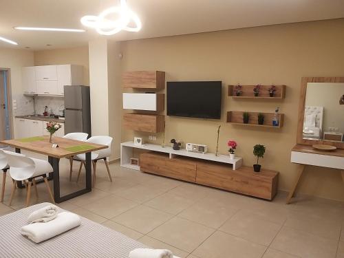 a living room with a table and a tv on the wall at Amazing Apartments @ Monastiraki Subway Station in Athens