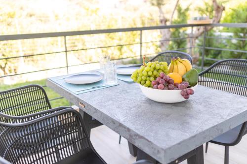 a bowl of fruit sitting on top of a table at Two Olive Trees - Deluxe Apartments in Psathopirgos