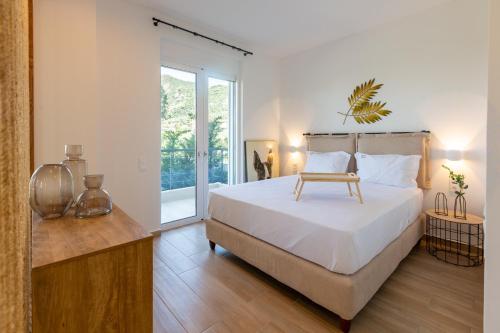 ein Schlafzimmer mit einem großen Bett und Holzboden in der Unterkunft Two Olive Trees - Deluxe Apartments in Psathopyrgos