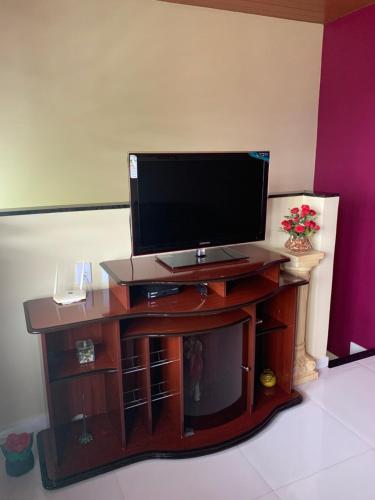a flat screen tv sitting on top of a wooden stand at Apartamento Central in Guaramiranga