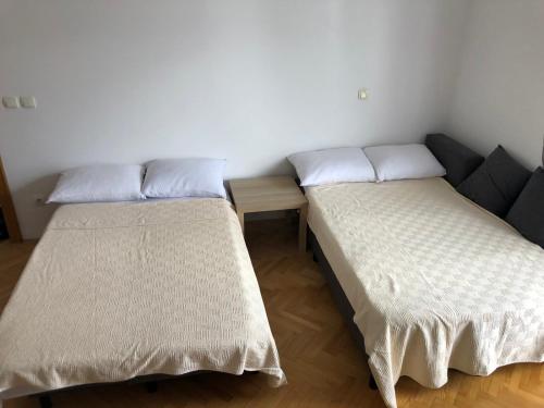dwa łóżka siedzące obok siebie w pokoju w obiekcie Apartment Simona w mieście Vrnjačka Banja