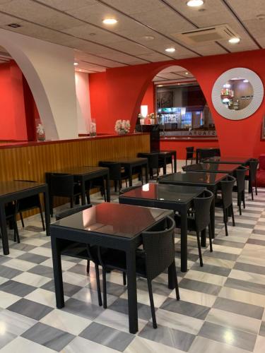 a restaurant with tables and chairs and red walls at Hotel Spa Pinar del Mar in Platja  d'Aro