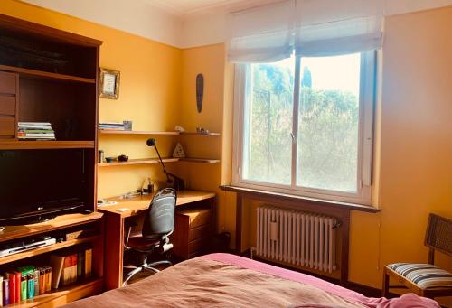 ein Schlafzimmer mit Bett, Schreibtisch und Fenster in der Unterkunft Villa Vert in Beccar