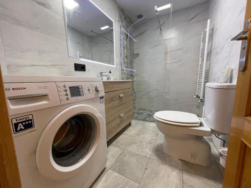 a bathroom with a washing machine and a toilet at Oktheway Montrove Terrace in Oleiros