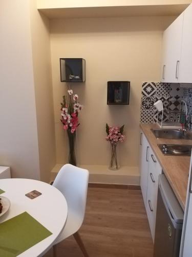 a kitchen with a table and a vase of flowers at Amazing Apartments @ Monastiraki Subway Station in Athens