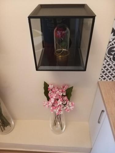 a shelf with a vase of flowers on a table at Amazing Apartments @ Monastiraki Subway Station in Athens