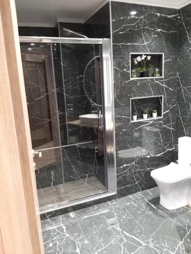 a black bathroom with a shower and a toilet at Amazing Apartments @ Monastiraki Subway Station in Athens