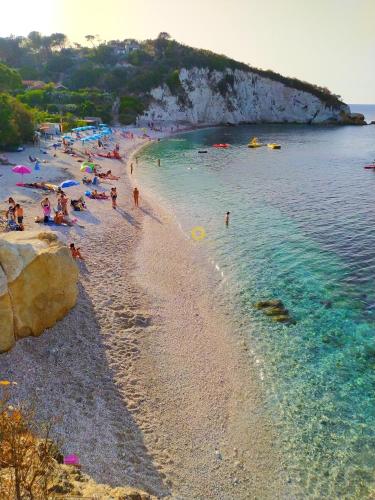 a beach with a bunch of people in the water at Ghiaie sea view in Portoferraio