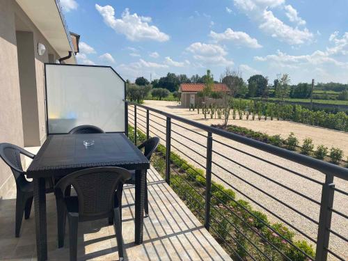 a table and chairs on a balcony with a view at Agricamping Al Grappolo di Vino in Lazise - Gardasee in Lazise