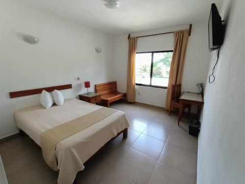 a hotel room with a bed and a television at Real Primaveras Campestre in Escárcega