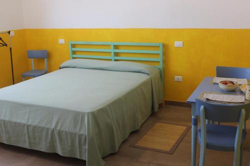 a bedroom with a bed and a table and chairs at Il Galletto bb in Patù