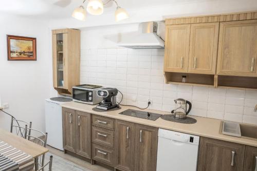 eine Küche mit Holzschränken und einer Mikrowelle in der Unterkunft ENKLAWA NAD KWISĄ [APARTAMENT 1] in Świeradów-Zdrój