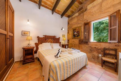 a bedroom with a bed in a room with a window at Es Rafalet - Sa Buhardilla Petita in Manacor