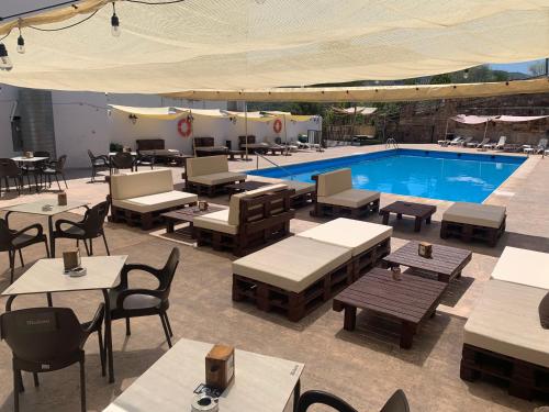 a swimming pool with tables and chairs next to a restaurant at Hotel Don Juan in Puente de Génave