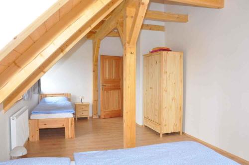 een slaapkamer met een bed en een houten zolder bij Holiday home in Zahori u Semil - Isergebirge 38483 