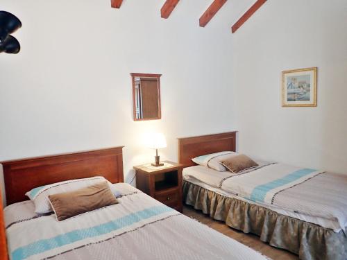 a bedroom with two beds and a table with a lamp at Holiday home in Starigrad-Paklenica 40978 in Starigrad-Paklenica