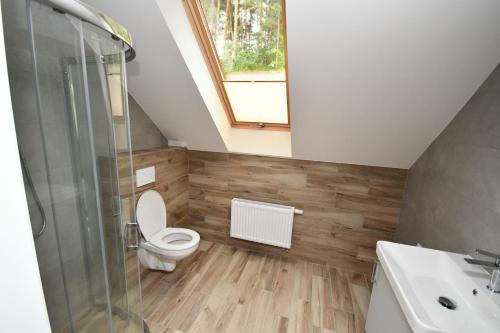 a bathroom with a toilet and a sink and a shower at Dom w głębi lasu in Suwałki