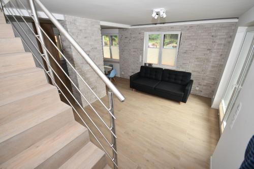 a living room with a black couch and a brick wall at Dom w głębi lasu in Suwałki