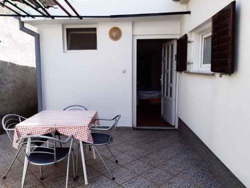 patio con mesa, sillas y puerta en Apartment in Senj 40198, en Senj