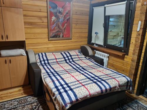 1 dormitorio con cama y ventana en Деревянный 2-х комнатный домик, en Kiev
