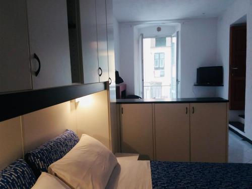 a bedroom with a bed and a kitchen with a window at Il Balconcino delle CinqueTerre in Vernazza