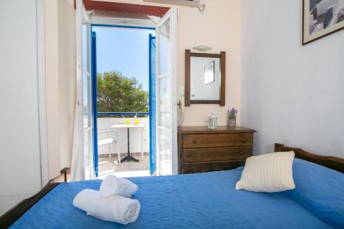 a bedroom with a blue bed with towels on it at Gardenia Hotel in Perissa