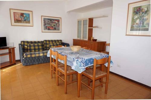 a living room with a table and chairs and a couch at Holiday home Porto Santa Margherita 40286 in Porto Santa Margherita di Caorle