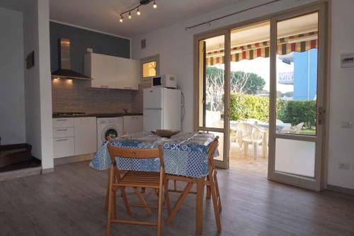 a kitchen with a table and chairs and a kitchen with a patio at Holiday home Porto Santa Margherita 40301 in Porto Santa Margherita di Caorle
