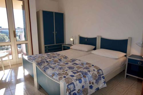 sypialnia z łóżkiem i dużym oknem w obiekcie Holiday home Porto Santa Margherita 40177 w mieście Porto Santa Margherita di Caorle