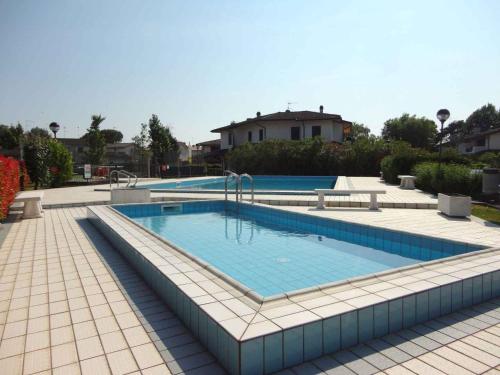 duży basen z niebieskimi płytkami na ziemi w obiekcie Holiday home Porto Santa Margherita 40177 w mieście Porto Santa Margherita di Caorle