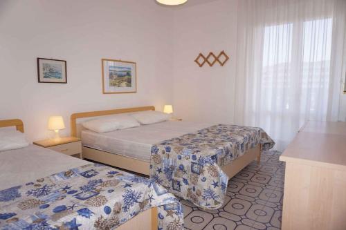 une chambre d'hôtel avec deux lits et une fenêtre dans l'établissement Apartment in Porto Santa Margherita 40140, à Porto Santa Margherita