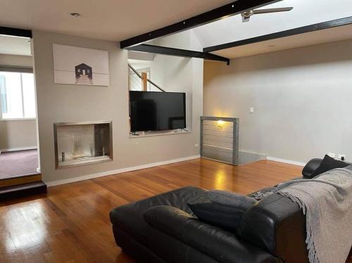 a living room with a couch and a fireplace at Central Executive Spa Apartment in Ballarat