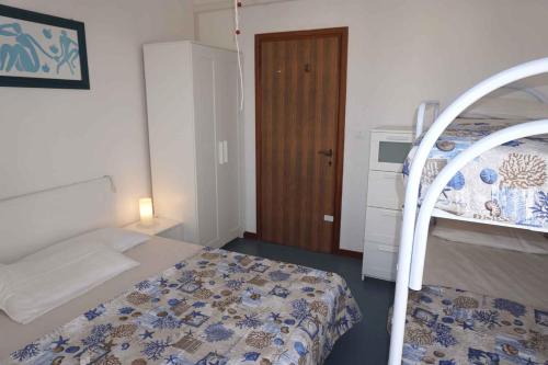 ein kleines Schlafzimmer mit einem Bett und einer Holztür in der Unterkunft Studio in Porto Santa Margherita 40176 in Porto Santa Margherita