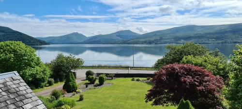a view of a lake with a bridge and mountains at CREAG DHUBH COUNTRY HOUSE in Inveraray