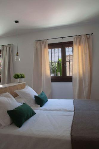 a bedroom with two beds and a window at Apartamentos Tres Llaves Palacio de Vela de los Cobos in Úbeda