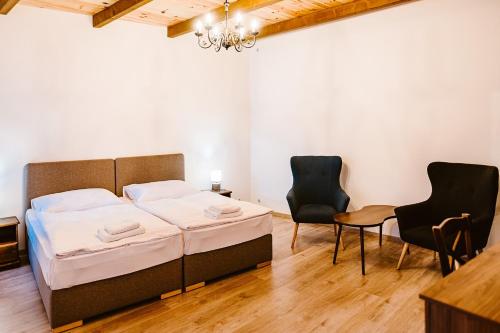 a bedroom with a bed and two chairs at sziklavendeghaz in Veszprém