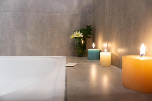 dos velas en un baño con un jarrón con flores en Belgrano Decks, en San Carlos de Bariloche