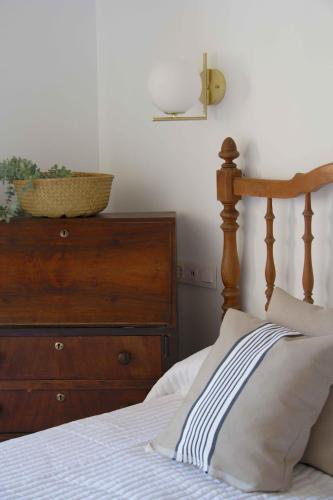 a bedroom with a bed and a wooden dresser at Apartamentos Tres Llaves Palacio de Vela de los Cobos in Úbeda