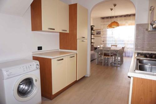 ポルト・サンタ・マルゲリータ・ディ・カオルレにあるHoliday home Porto Santa Margherita 40137のキッチン(洗濯機付)、ダイニングルーム