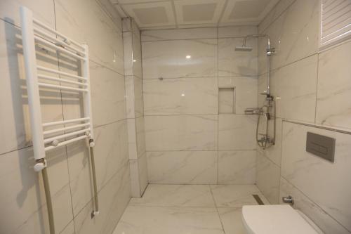 a white bathroom with a shower and a toilet at Kommageneiz hotel in Adıyaman